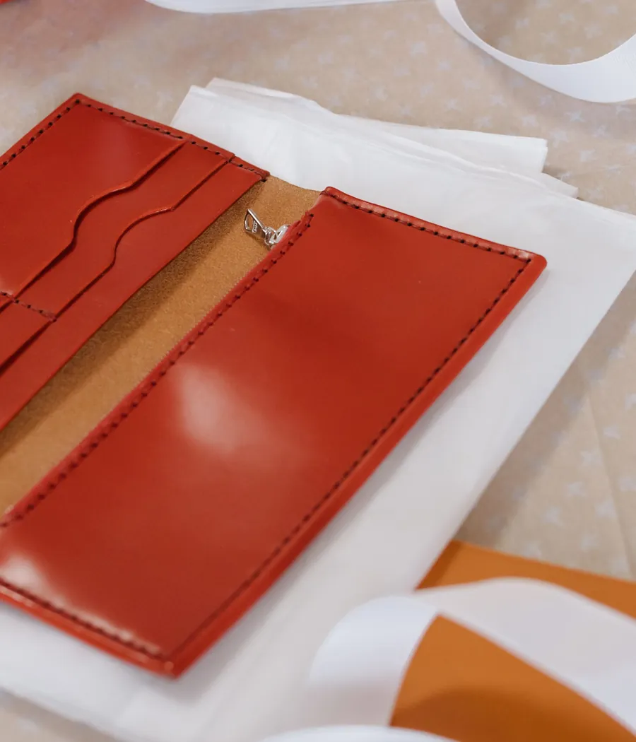 Close view of a stitched red leather card holder