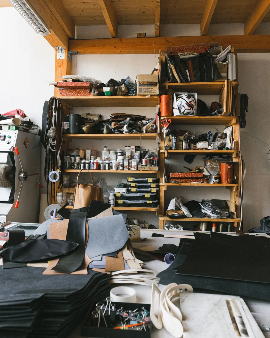 Organized leather workshop with shelves, patterns, and materials