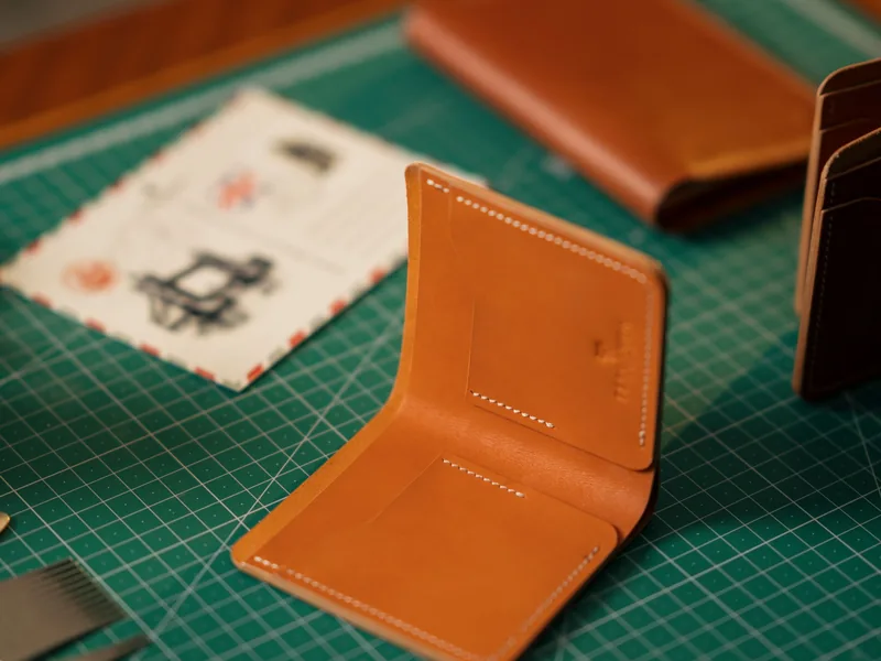 Handcrafted leather wallets displayed on a cutting mat